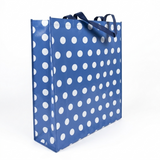 Blue shopping bag with white polka dots on a white background