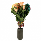 Bouquet of artificial flowers in a green vase on a white background