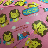 Pink umbrella with cartoon lion designs and text on a pink background
